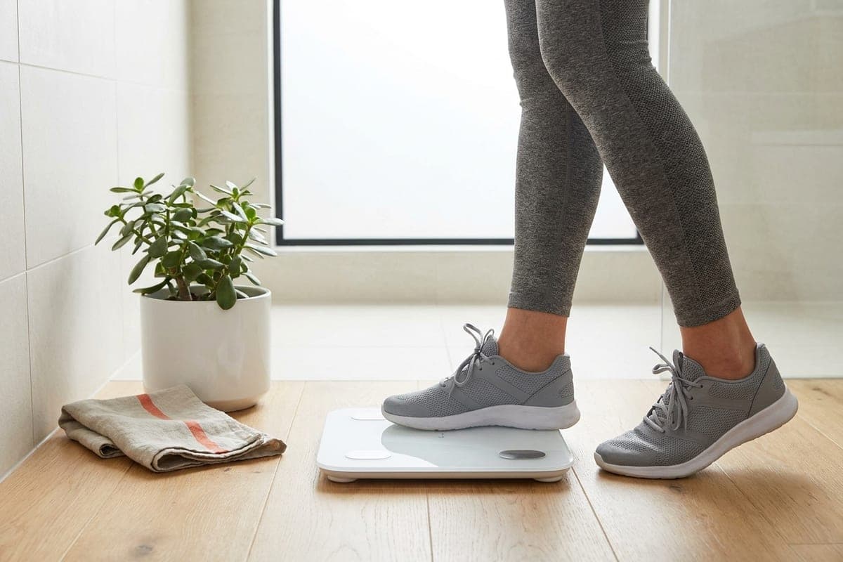 A person stepping onto a bathroom scale